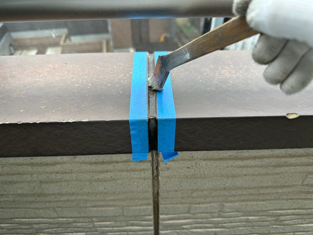 笠木繋ぎ目プライマー塗布<br />
（外壁とコーキングを密着させる為の接着剤です。とても重要な工程です。）
