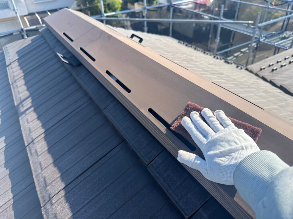 屋根板金ケレン<br />
（専用の道具で傷をつけて塗料の密着をよくする為の下地調整です。）