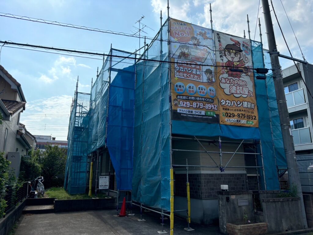 足場組立<br />
（塗料が飛散しないようにメッシュシートもしっかりと貼りました。）