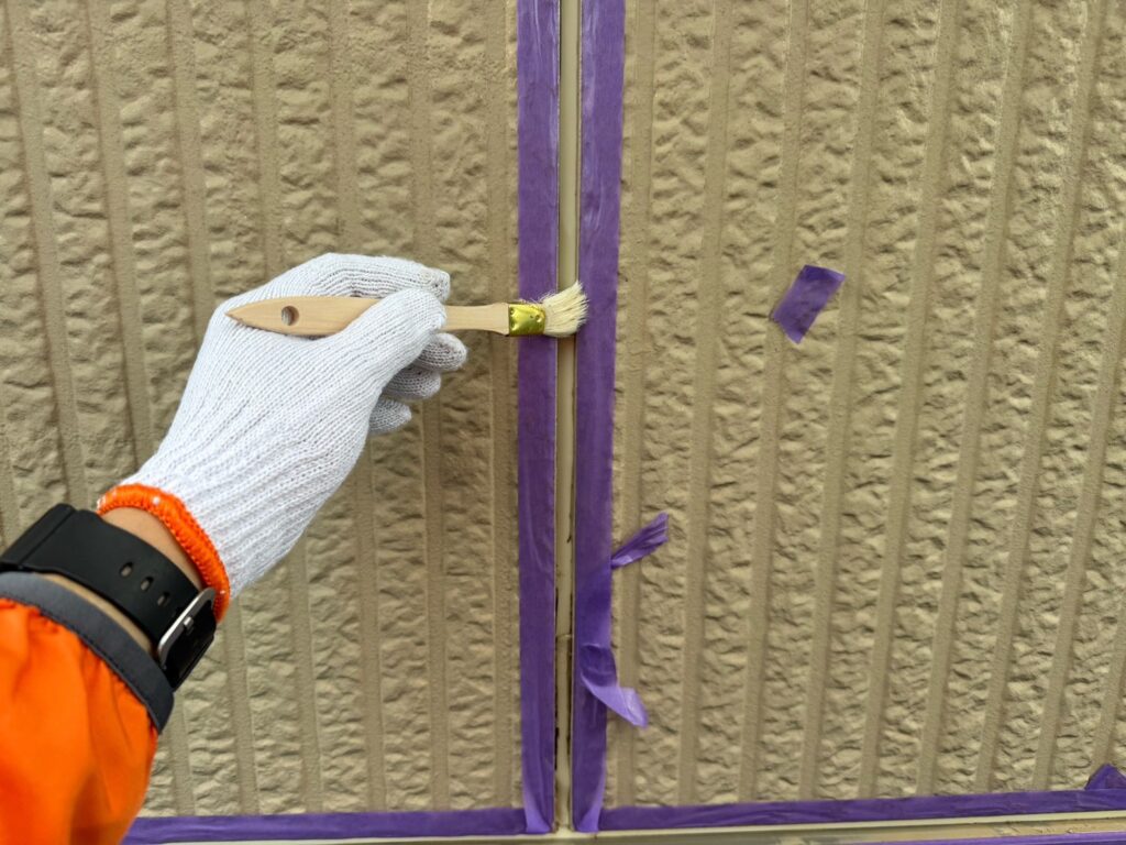 目地コーキングプライマー塗布<br />
（外壁とコーキングを密着させる為の接着剤です。とても重要な工程です。）