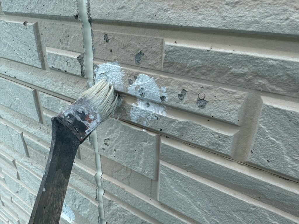 外壁剥がれ部：下地補修<br />
パテを形成する前に接着剤を塗布しました。