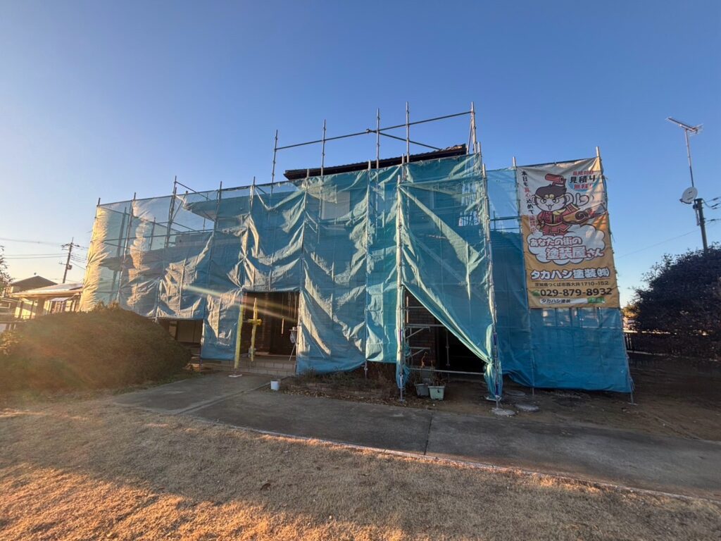 足場組立<br />
（塗料が飛散しないようにメッシュシートもしっかりと貼りました。）