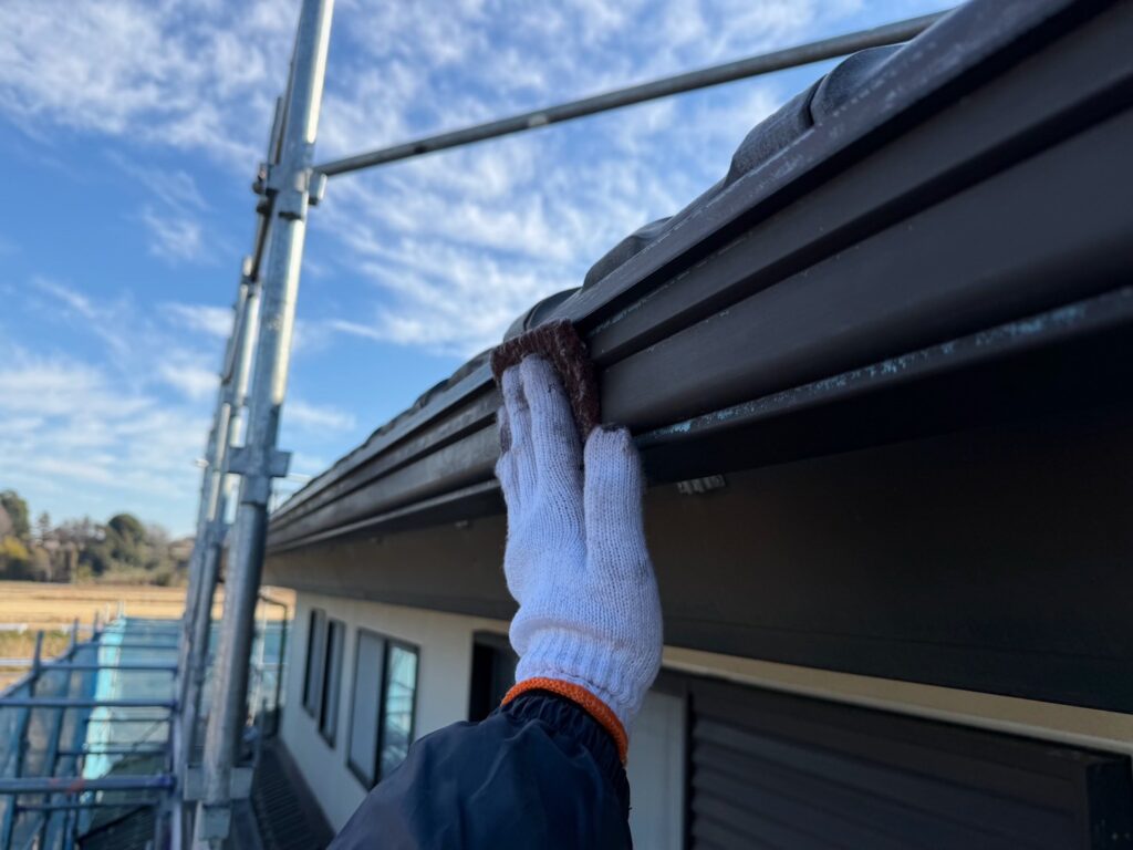 雨どいケレン<br />
（ケレンとは、塗料との密着を良くするために、専用の道具にて細かい傷をつける下地調整です。）