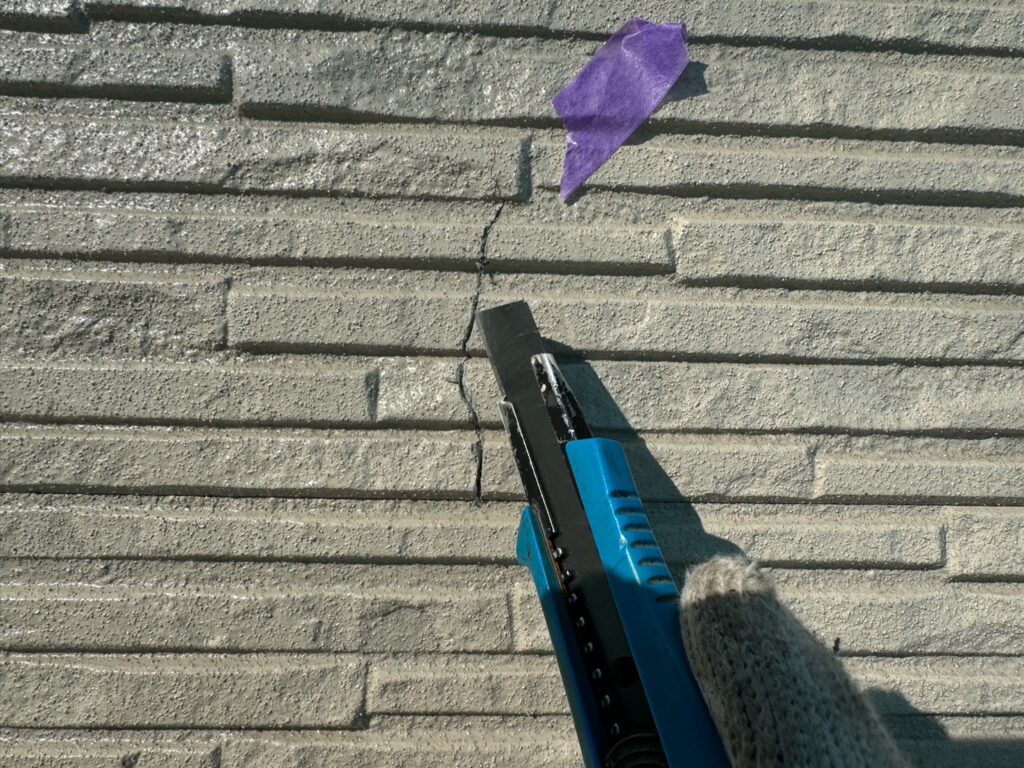 外壁ひび割れ：下地補修<br />
補修材を詰めるためにカッターで隙間を作りました。