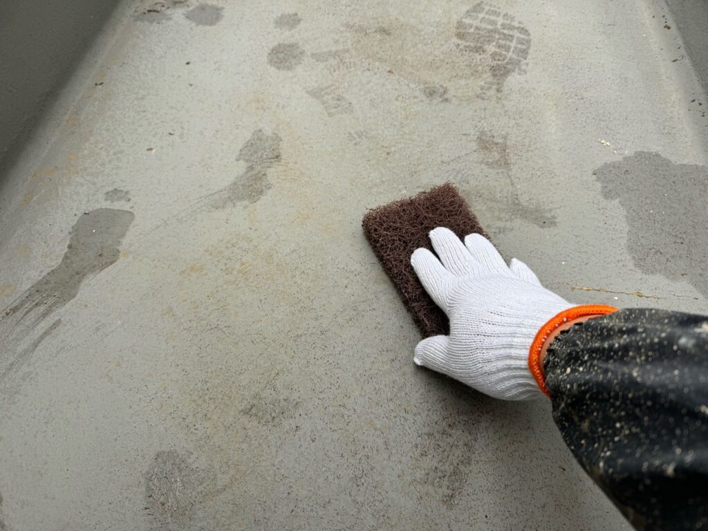 ベランダ（FRP）：ケレン<br />
塗料との密着を良くするために、専用の道具にて細かい傷をつける下地調整です。）