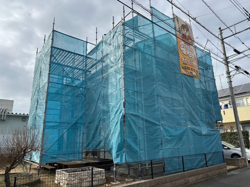 足場組立<br />
（塗料が飛散しないようにメッシュシートもしっかりと貼りました。）