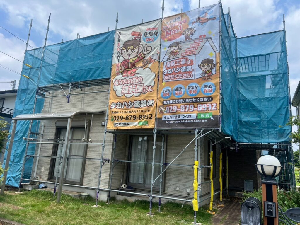 足場組立<br />
（塗料が飛散しないようにメッシュシートもしっかりと貼りました。）