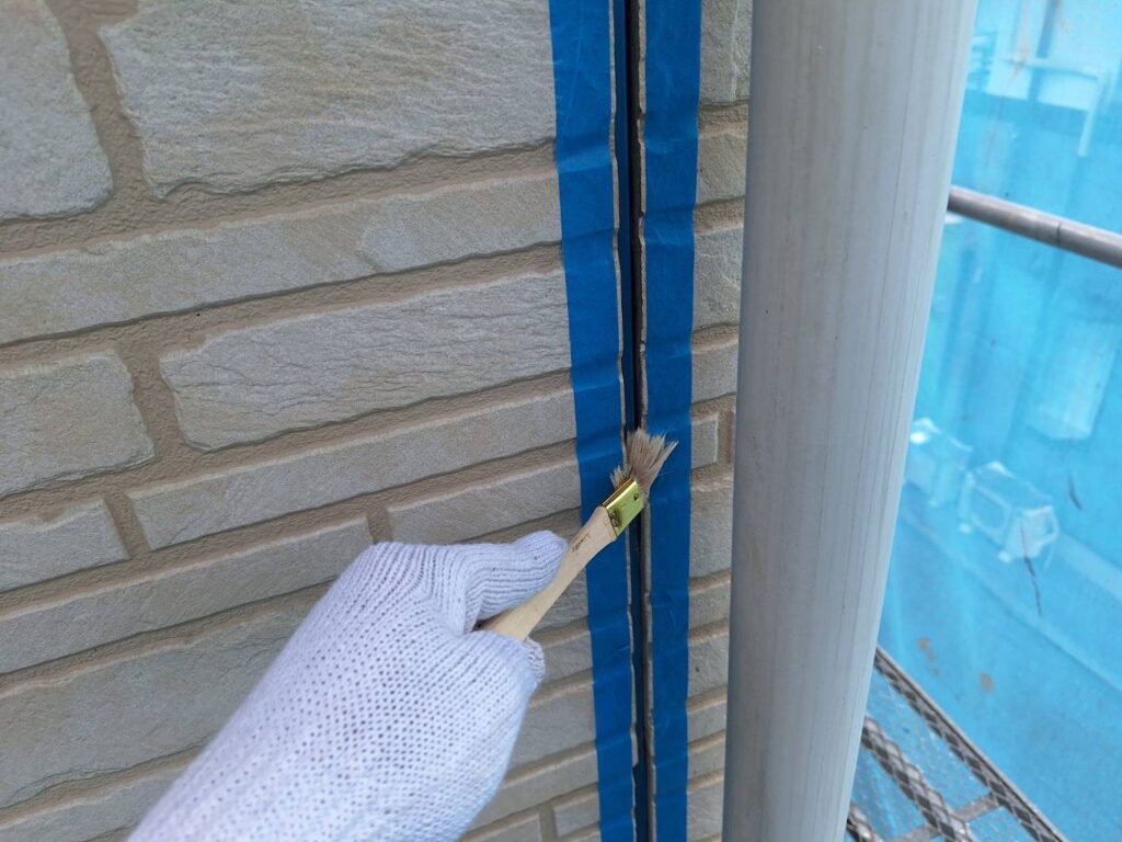 コーキング：プライマー塗布<br />
（外壁とコーキングを密着させる為の接着剤です。とても重要な工程です。）