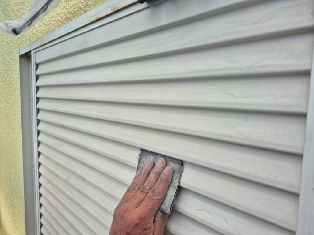 雨戸：ケレン<br />
（専用の道具で傷をつけて塗料の密着をよくする為の下地調整です。）