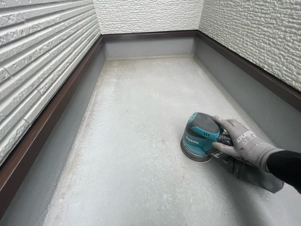 ベランダ（FRP）：ケレン<br />
塗料との密着を良くするために、専用の道具にて細かい傷をつける下地調整です。）