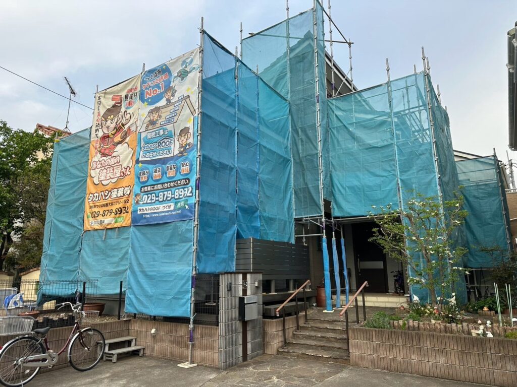 足場組立<br />
（塗料が飛散しないようにメッシュシートもしっかりと貼りました。）