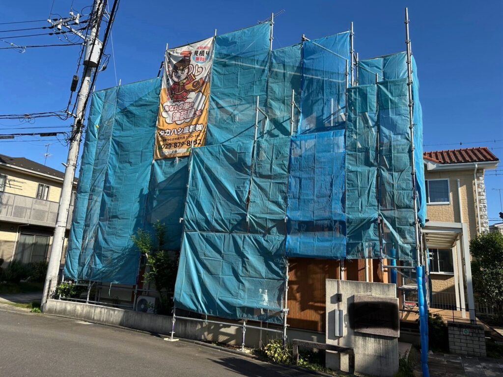 足場組立<br />
（塗料が飛散しないようにメッシュシートもしっかりと貼りました。）