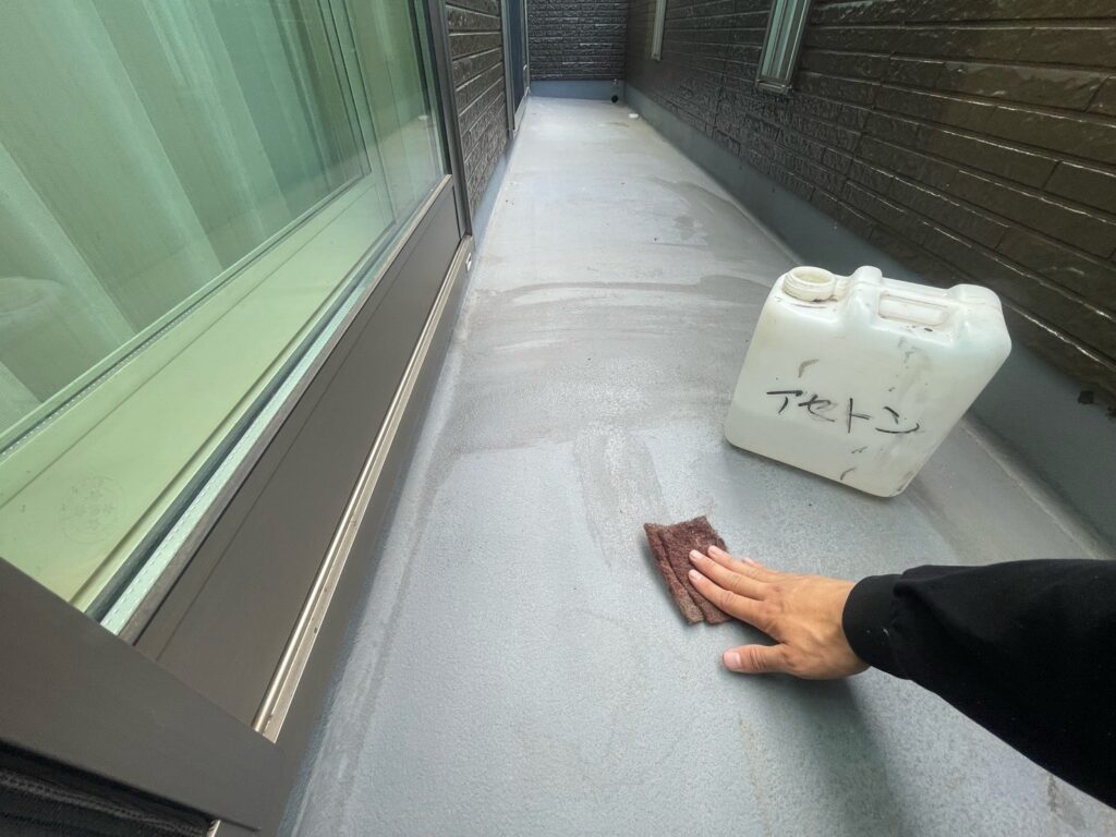 ベランダ（FRP）：アセトン拭き<br />
（油分を取るためにアセトン拭きを行いました。とても重要な工程です。）