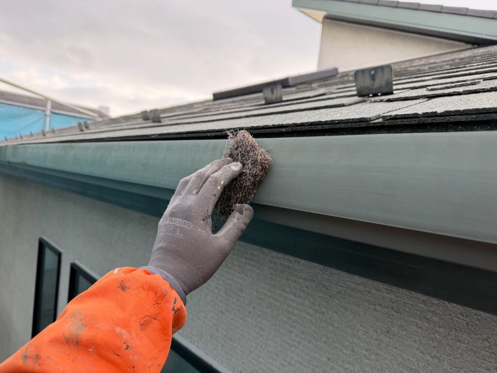 雨どいケレン<br />
（ケレンとは、塗料との密着を良くするために、専用の道具にて細かい傷をつける下地調整です。）